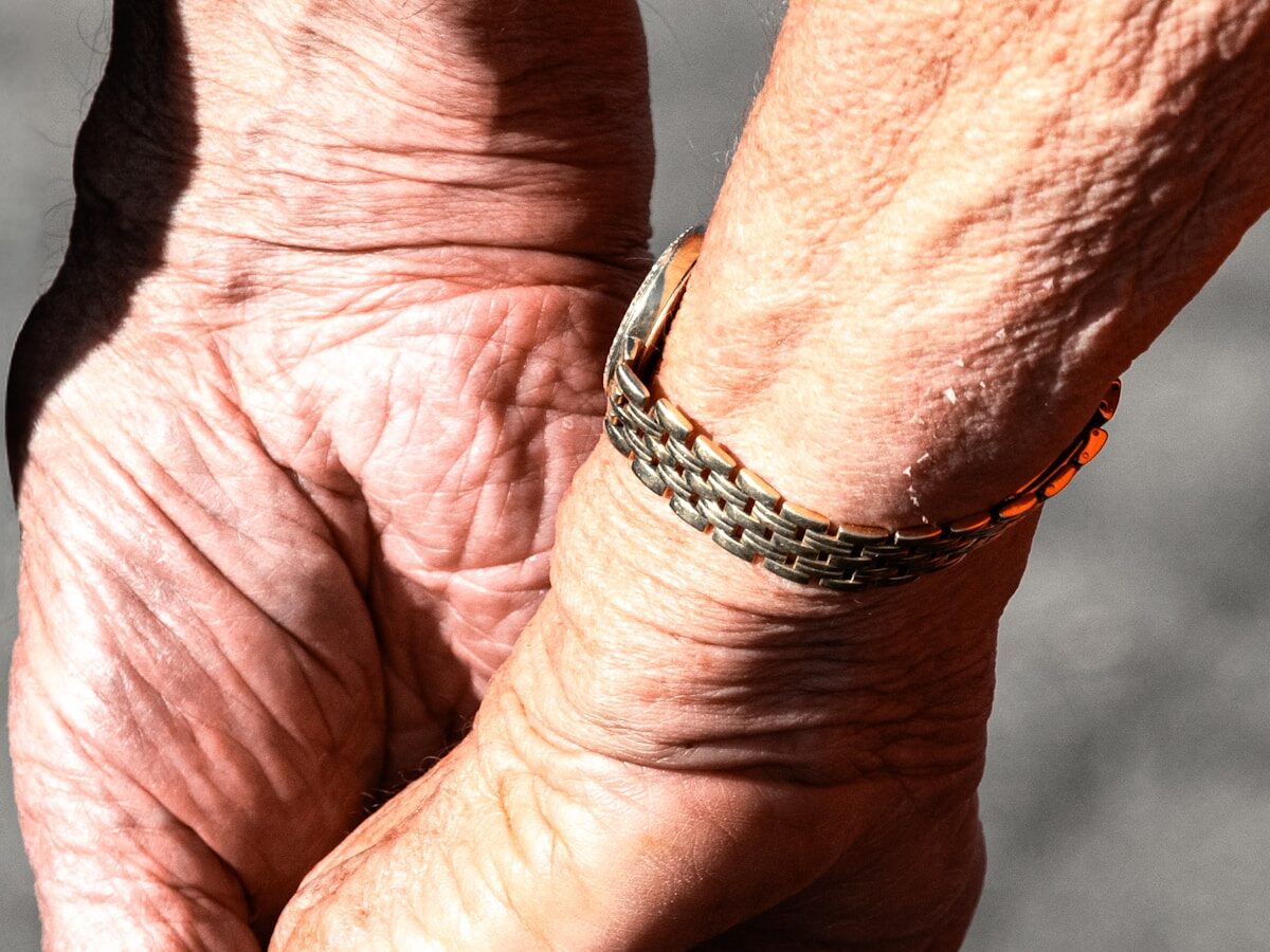 Mãos idosas seguradas com cuidado, simbolizando a presença e o cuidado em cuidados paliativos