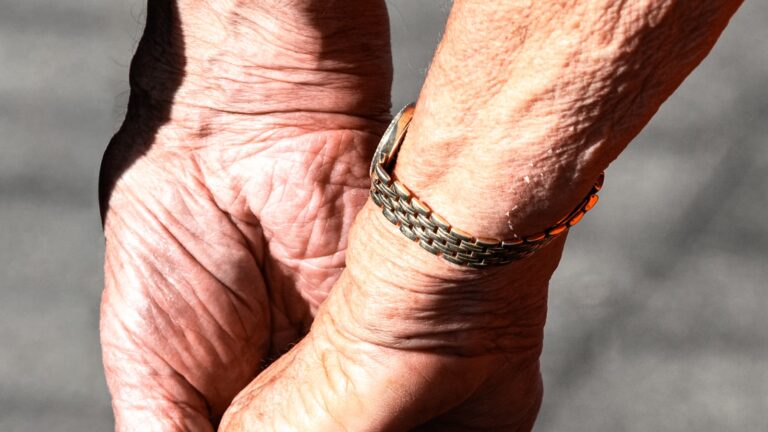 Mãos idosas seguradas com cuidado, simbolizando a presença e o cuidado em cuidados paliativos