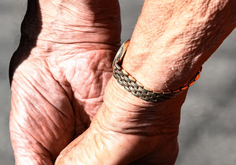 Mãos idosas seguradas com cuidado, simbolizando a presença e o cuidado em cuidados paliativos